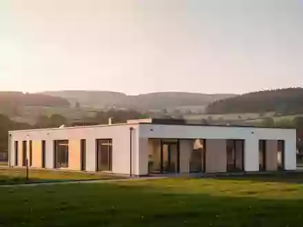 Modernes Gesundheitszentrum in einer ruhigen Thüringer Hügellandschaft bei Sonnenuntergang. - Foto: über boerse-global.de