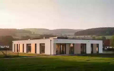 Modernes Gesundheitszentrum in einer ruhigen Thüringer Hügellandschaft bei Sonnenuntergang. - Foto: über boerse-global.de