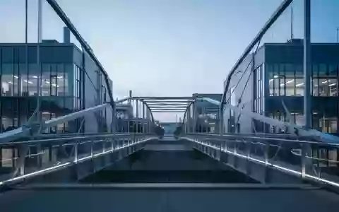 Eine moderne Architekturbrücke zwischen zwei Forschungsgebäuden in der Abenddämmerung. - Foto: über boerse-global.de