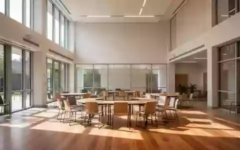 Ein heller, minimalistischer Gemeinschaftsraum mit Holzfußboden, leeren Stühlen und Tischen, durchflutet von natürlichem Licht. - Foto: über boerse-global.de