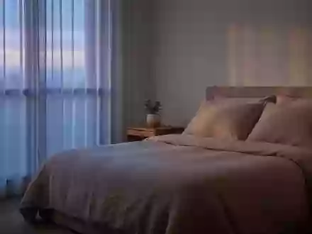 Ein ruhiges, minimalistisch eingerichtetes Schlafzimmer mit neutraler Bettwäsche und sanftem Tageslicht, das eine Atmosphäre der Erholung vermittelt. - Foto: über boerse-global.de