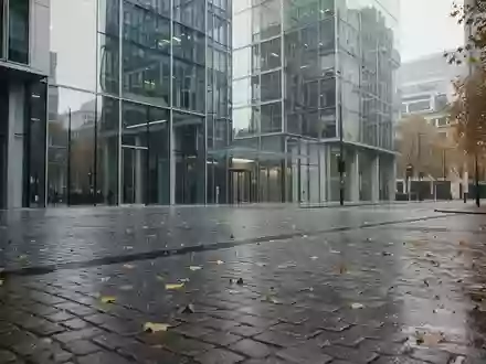 Moderne Bürogebäude in einem Londoner Finanzviertel, reflektiert in nassem Kopfsteinpflaster an einem bewölkten Tag. - Foto: über boerse-global.de