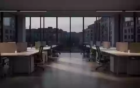 Ein leerer, modern gestalteter Großraumbürobereich in der Dämmerung mit minimalistischen Arbeitsplätzen und natürlichem Licht. - Foto: über boerse-global.de