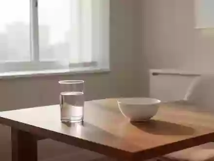 Ein heller, minimalistischer Behandlungsraum mit einem Glas Wasser und einer leeren Schale auf einem Holztisch. - Foto: über boerse-global.de