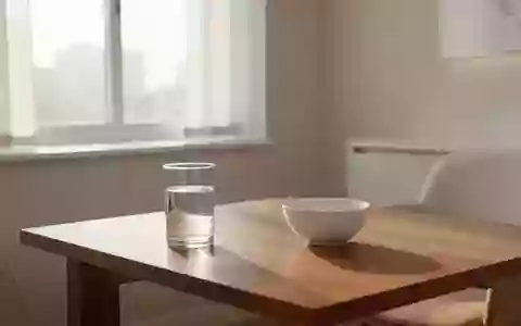 Ein heller, minimalistischer Behandlungsraum mit einem Glas Wasser und einer leeren Schale auf einem Holztisch. - Foto: über boerse-global.de