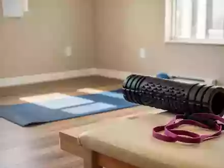 Ein heller, minimalistischer Physiotherapieraum mit Sportgeräten wie einer Yogamatte und einer Faszienrolle auf dem Boden. - Foto: über boerse-global.de