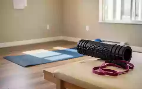 Ein heller, minimalistischer Physiotherapieraum mit Sportgeräten wie einer Yogamatte und einer Faszienrolle auf dem Boden. - Foto: über boerse-global.de