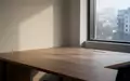 Ein leerer, minimalistischer Arbeitsplatz mit Holztisch in einem hellen Raum bei Tageslicht. - Foto: über boerse-global.de