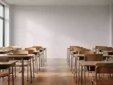 Ein leerer, sonnendurchfluteter Klassenraum mit schlichten Holztischen und Stühlen in einer ruhigen, minimalistischen Atmosphäre. - Foto: über boerse-global.de