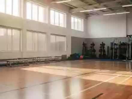 Eine leere, helle Sporthalle mit poliertem Holzboden und natürlichem Lichteinfall. - Foto: über boerse-global.de