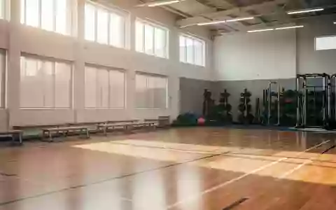 Eine leere, helle Sporthalle mit poliertem Holzboden und natürlichem Lichteinfall. - Foto: über boerse-global.de