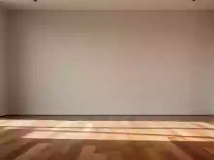 Ein minimalistischer, heller Fitnessraum mit einer schlichten Wand und einem Holzboden in natürlichem Tageslicht. - Foto: über boerse-global.de