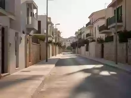 Leere Wohnstraße in einer sonnigen Stadt mit Betonbürgersteigen und Steinfassaden bei Tageslicht. - Foto: über boerse-global.de