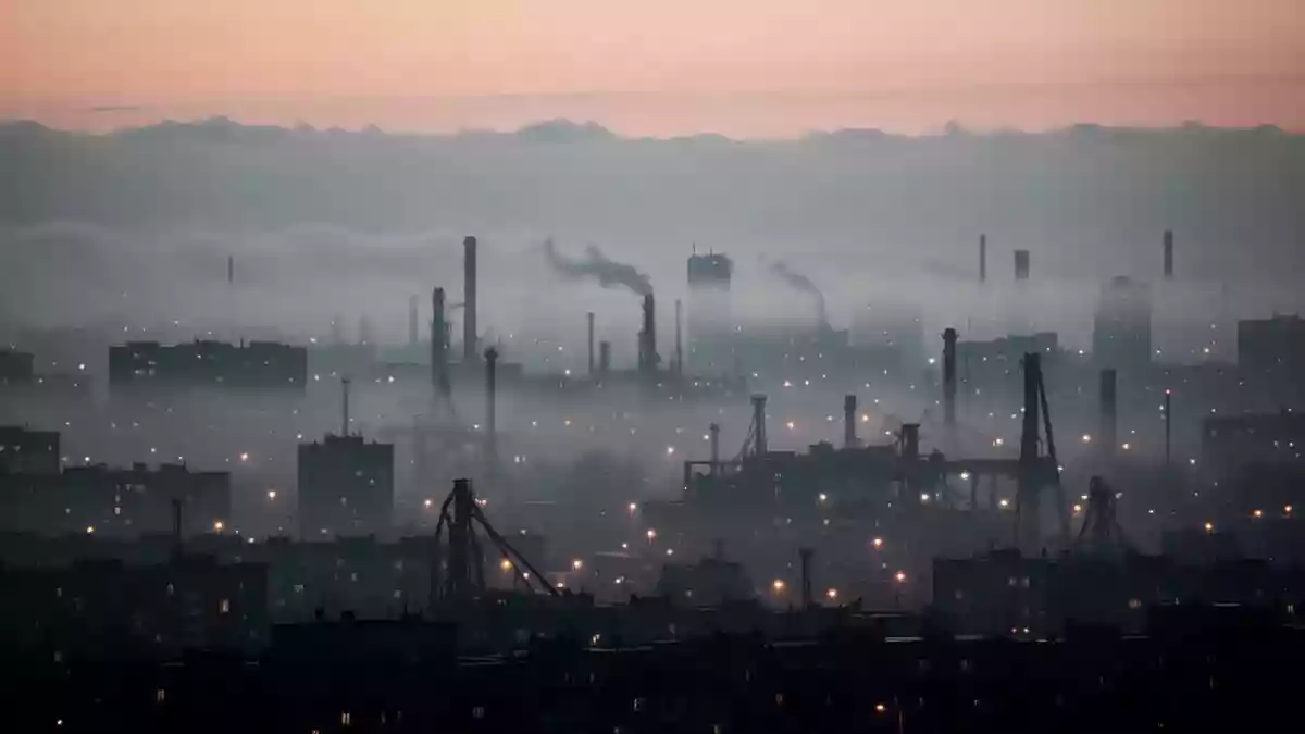 Dichte Dunstglocke über einer städtischen Skyline bei Dämmerung, die die Sicht durch Feinstaubpartikel in der Luft trübt. Illustration mit AI erstellt.
