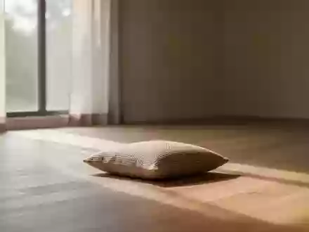 Ein minimalistischer, ruhiger Raum mit natürlichem Lichteinfall und einem einzelnen Sitzkissen auf einem Holzboden. - Foto: über boerse-global.de