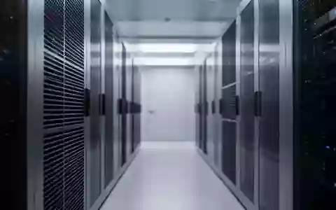 Ein minimalistischer, hochmoderner Serverraum mit fokusierter Beleuchtung auf metallischen Oberflächen und Lüftungsschlitzen. - Foto: über boerse-global.de