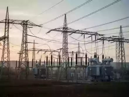 Ein Umspannwerk mit Strommasten und Leitungen in einer weiten Landschaft bei Tagesanbruch. - Foto: ĂĽber boerse-global.de