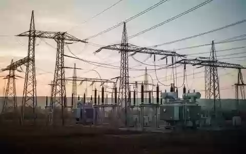Ein Umspannwerk mit Strommasten und Leitungen in einer weiten Landschaft bei Tagesanbruch. - Foto: über boerse-global.de