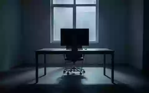 Ein unbesetzter, schattiger Arbeitsplatz in einem minimalistischen Büro mit einem ausgeschalteten Computerbildschirm. - Foto: über boerse-global.de