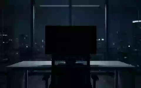 Ein dunkler, moderner Büroarbeitsplatz mit einem ausgeschalteten Computerbildschirm in einer minimalistischen Umgebung. - Foto: über boerse-global.de