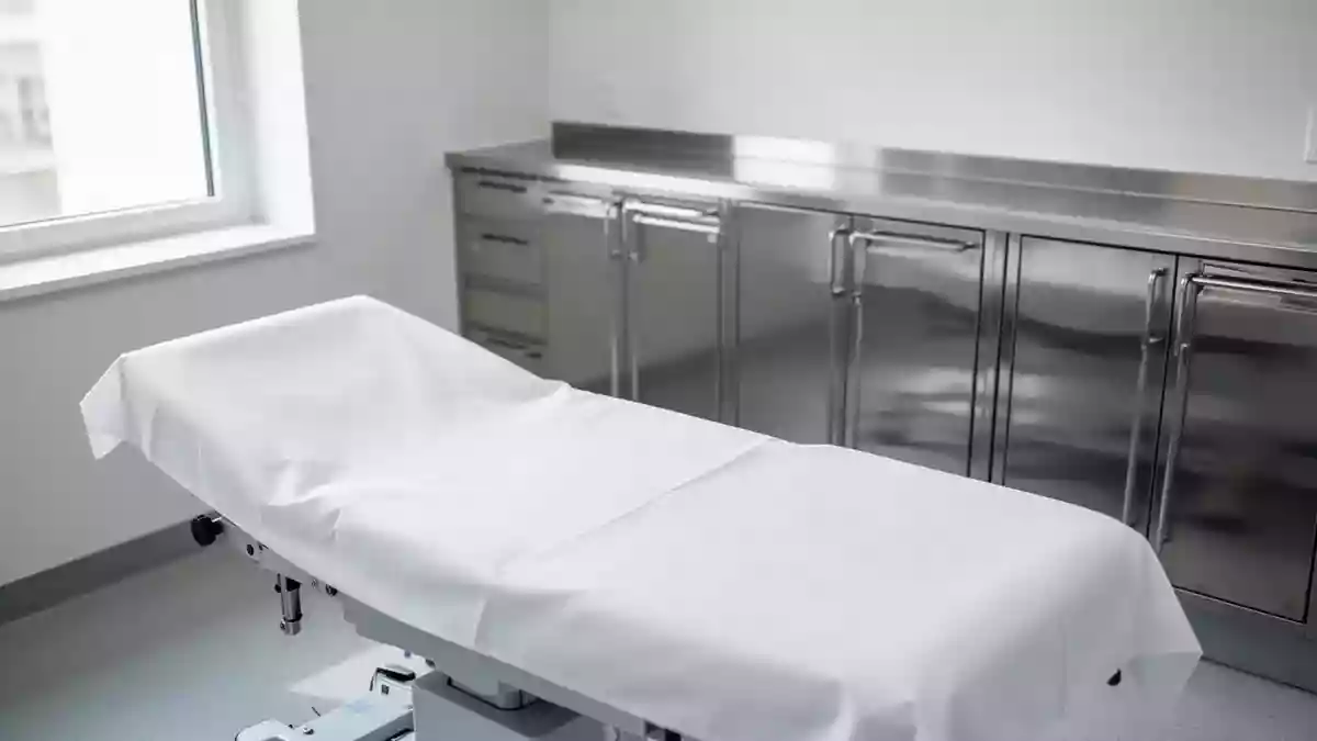 Ein steriler, leerer Untersuchungsraum in einer orthopädischen Praxis mit einer weißen Behandlungsliege. Illustration mit AI erstellt.