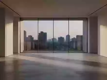 Ein minimalistischer, lichtdurchfluteter Raum mit poliertem Betonboden und Blick auf eine ruhige Skyline bei Dämmerung. - Foto: über boerse-global.de