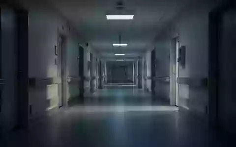 Ein leerer, steriler Krankenhausflur bei Dämmerung mit langen Schatten auf dem Boden. - Foto: über boerse-global.de