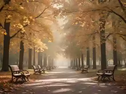 Ein sonnendurchfluteter Parkweg mit herbstlichen Bäumen und leeren Holzbänken in einer ruhigen Grünanlage. - Foto: über boerse-global.de