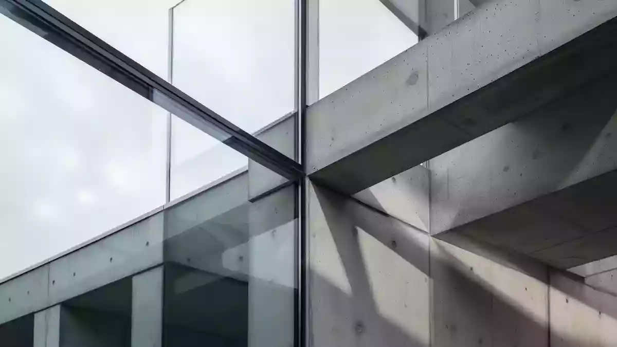 Abstrakte Architekturdetails aus Glas und Beton in natürlichem Tageslicht, die Stabilität und Präzision symbolisieren. Illustration mit AI erstellt.