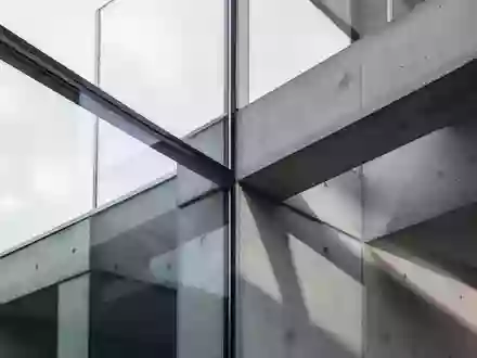 Abstrakte Architekturdetails aus Glas und Beton in natürlichem Tageslicht, die Stabilität und Präzision symbolisieren. - Foto: über boerse-global.de