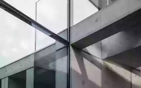 Abstrakte Architekturdetails aus Glas und Beton in natürlichem Tageslicht, die Stabilität und Präzision symbolisieren. - Foto: über boerse-global.de