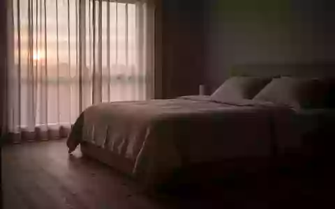 Ein minimalistisch eingerichtetes, ruhiges Schlafzimmer bei Tagesanbruch, das eine Atmosphäre der Erholung vermittelt. - Foto: über boerse-global.de