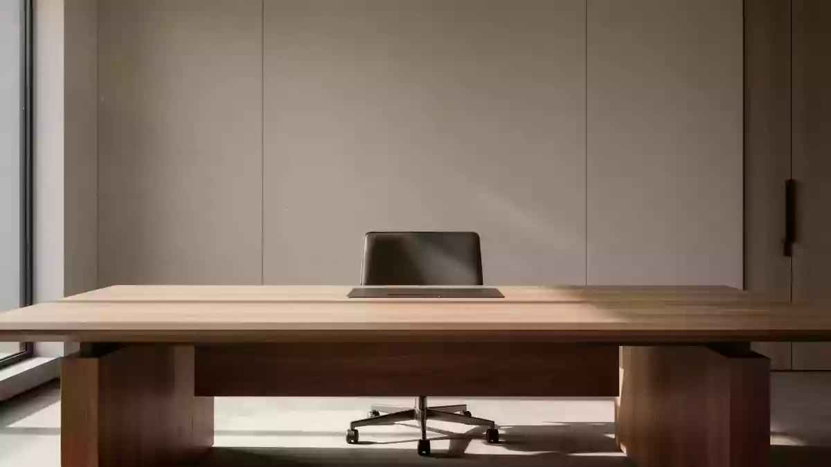 Ein leerer, aufgeräumter Schreibtisch in einem modernen Büro bei natürlichem Lichteinfall. Illustration mit AI erstellt.
