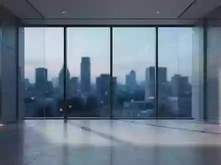 Ein minimalistisches, modernes Bürogebäude mit großen Glasfronten und Blick auf eine Stadt bei Dämmerung. - Foto: über boerse-global.de