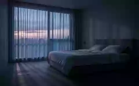 Ein minimalistisch eingerichtetes Schlafzimmer in den frühen Morgenstunden mit sanftem, durch Vorhänge fallendem Licht. - Foto: über boerse-global.de