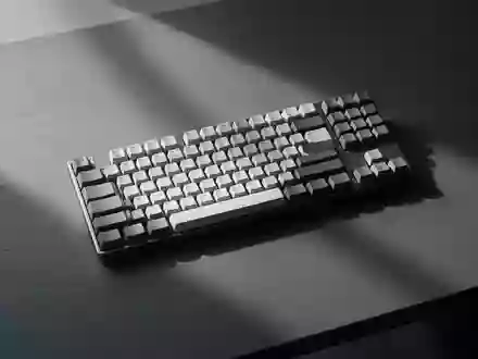 Eine minimalistische, dunkle Schreibtischoberfläche mit einer leeren Tastatur im sanften Morgenlicht. - Foto: über boerse-global.de