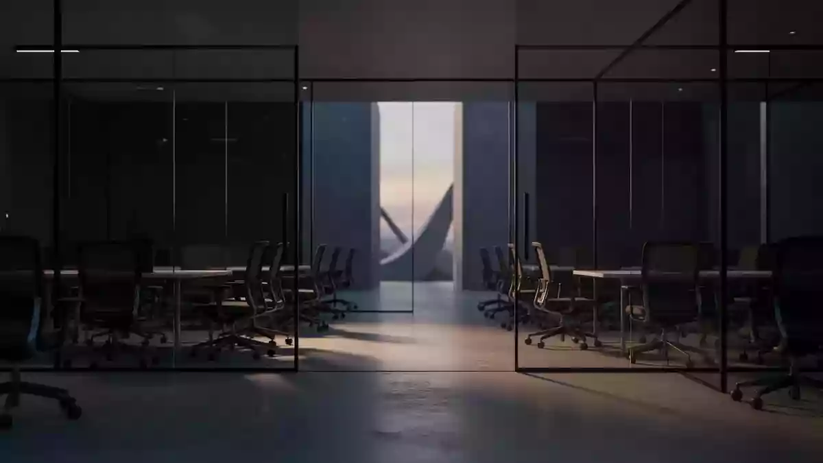 Ein minimalistisch eingerichteter, leerer Büroflur bei Dämmerung mit dunklen Glaswänden und Schattenwürfen auf dem Boden. Illustration mit AI erstellt.