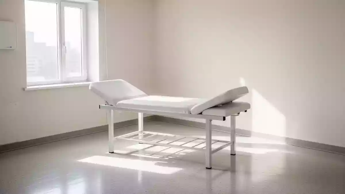 Ein heller, minimalistischer medizinischer Untersuchungsraum mit einer leeren Untersuchungsliege in klinischer Umgebung. Illustration mit AI erstellt.