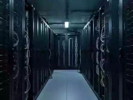 Ein minimalistisch beleuchteter Serverraum mit Industrieregalen und komplexen Kabelstrukturen in kühler Lichtstimmung. - Foto: über boerse-global.de