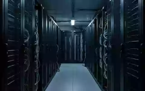 Ein minimalistisch beleuchteter Serverraum mit Industrieregalen und komplexen Kabelstrukturen in kühler Lichtstimmung. - Foto: über boerse-global.de