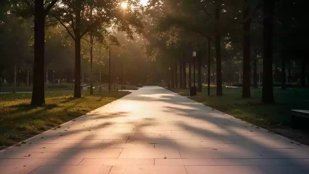 Ein sonnendurchfluteter Parkweg am späten Nachmittag ohne Personen, der Ruhe und Bewegung im Freien symbolisiert. Illustration mit AI erstellt.