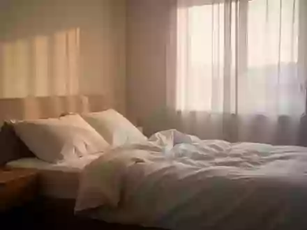 Ein minimalistisch eingerichtetes Schlafzimmer in den frühen Morgenstunden mit sanftem Tageslicht. - Foto: über boerse-global.de