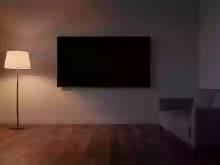 Ein minimalistisch eingerichtetes Wohnzimmer mit einem ausgeschalteten, leeren Fernsehbildschirm an einer kahlen Wand. - Foto: über boerse-global.de