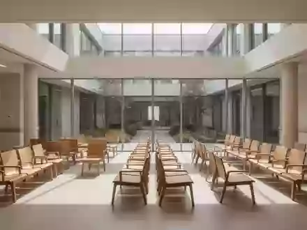 Ein heller, moderner Wartebereich in einer Klinik mit leeren Stühlen und architektonischem Fokus auf klare Linien. - Foto: über boerse-global.de