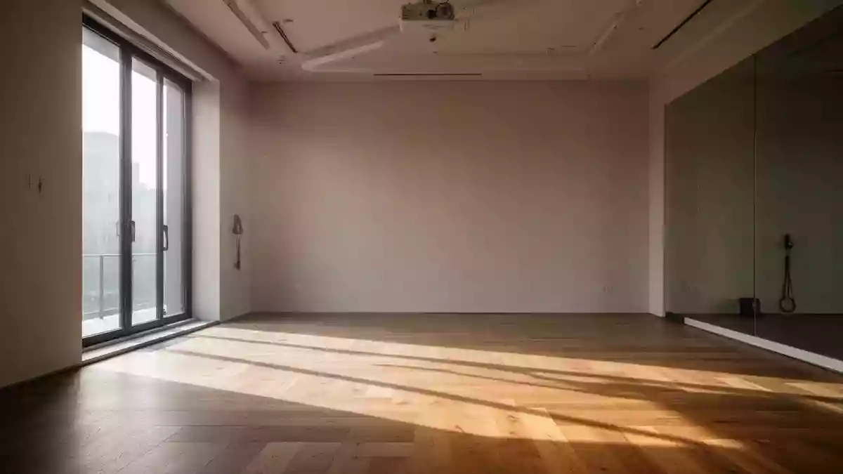 Ein minimalistisch gestalteter, heller Fitnessraum mit Holzboden und einfallendem Tageslicht. Illustration mit AI erstellt.