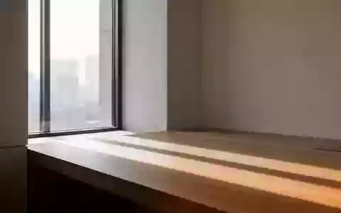 Ein minimalistischer, heller Raum mit klaren architektonischen Linien und sanftem Lichteinfall auf einer Holzoberfläche. - Foto: über boerse-global.de