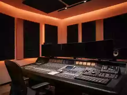 Ein minimalistisches Tonstudio mit akustischen Wandpaneelen und ausgeschalteten Mischpulten in stimmungsvollem Licht. - Foto: über boerse-global.de