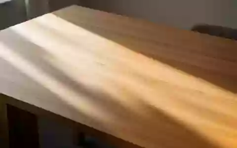 Ein minimalistischer, leerer Schreibtisch aus Holz mit weichem Lichteinfall und deutlichen Schattenwürfen. - Foto: über boerse-global.de