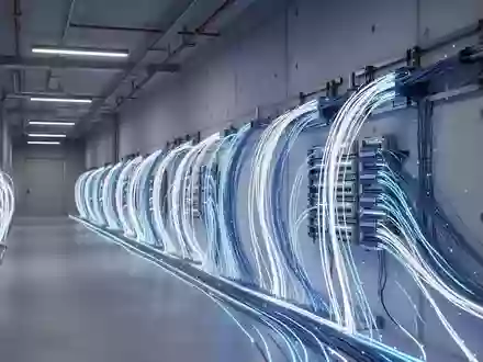 Modernes Glasfaser-Infrastruktur-Design in einem Rechenzentrum mit blau leuchtenden Kabeln an einer Betonwand. - Foto: über boerse-global.de
