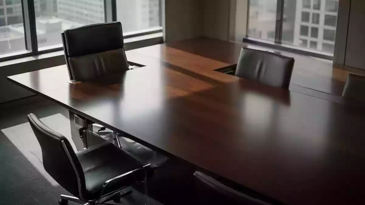 Ein moderner, leerer Konferenztisch in einem hellen Büro, der eine professionelle und seriöse Geschäftsatmosphäre vermittelt. Illustration mit AI erstellt.